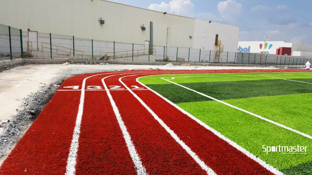 pista de atletismo sintética de pasto sintético instalada por Sportmaster junto a cancha de fútbol